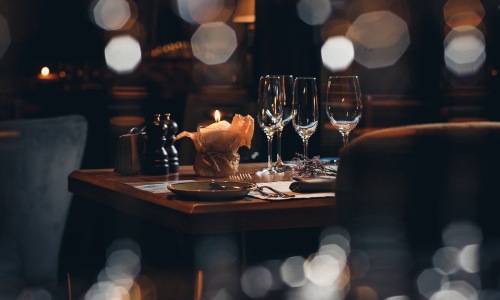 wine glasses and a candle in a warm lit restaurant
