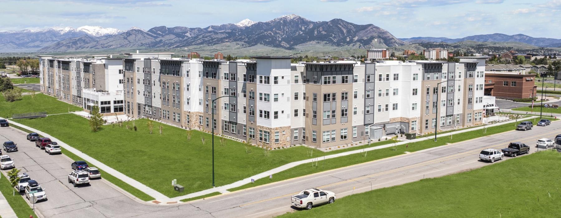 a large white building with cars on the road