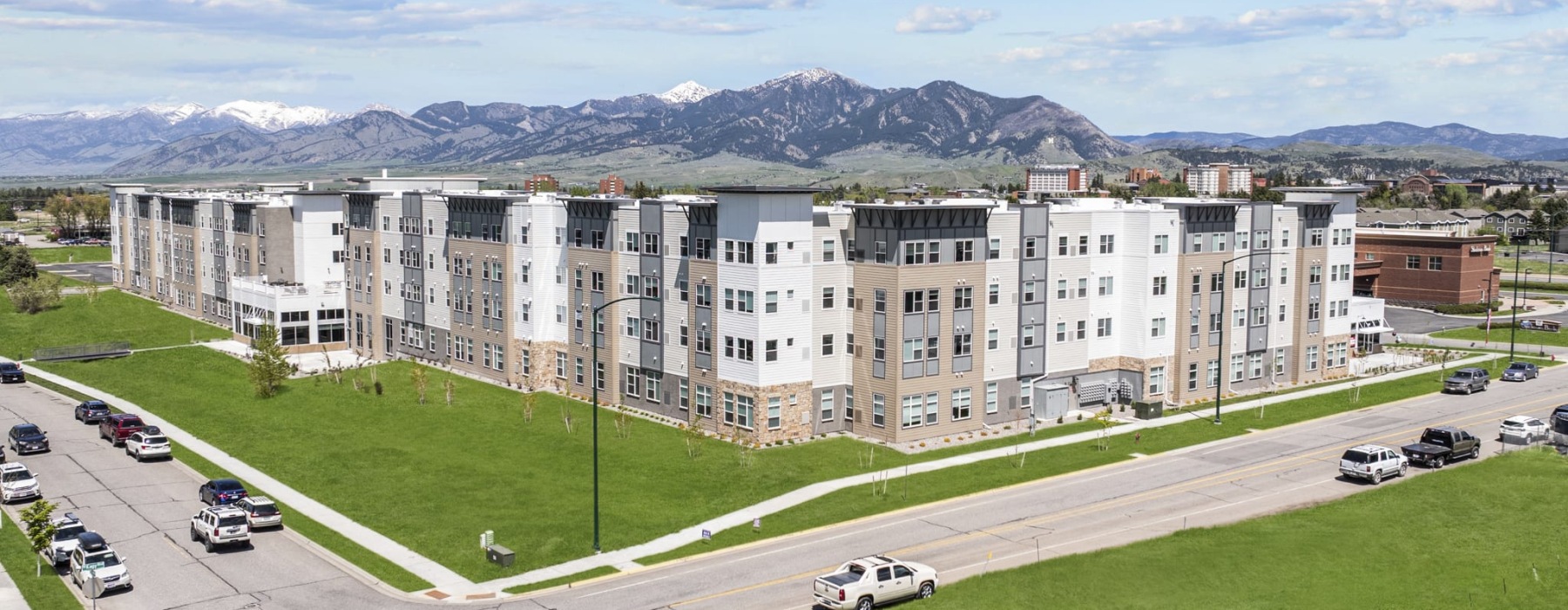 a large white building with cars on the road